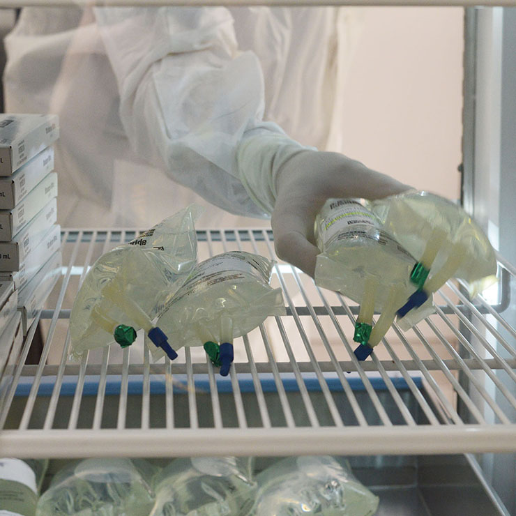 Ray Hayes, CPhT, puts the medication in the two-sided refrigerator for later use.