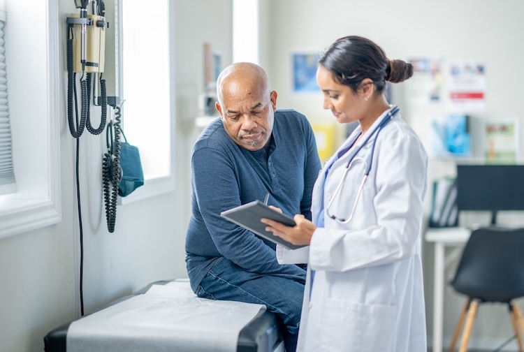 Female doctor shows male patient his medical charts