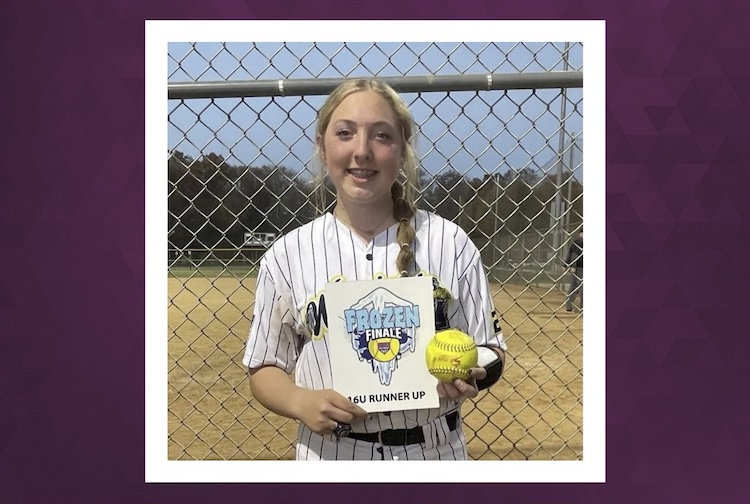 Girl in a softball uniform holding a sign