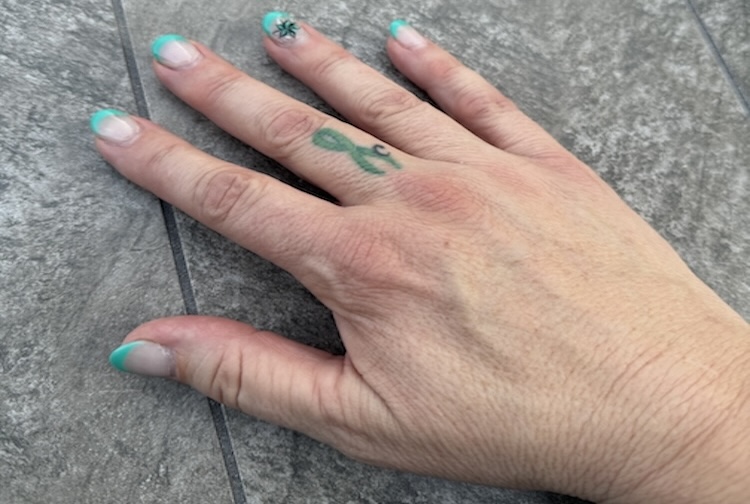 Hand with tattoo on the middle finger