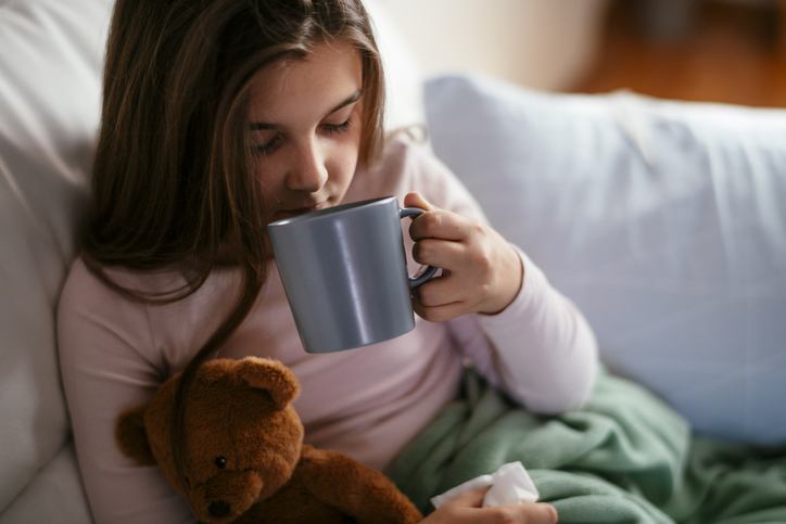 little girl drinking tea at home 