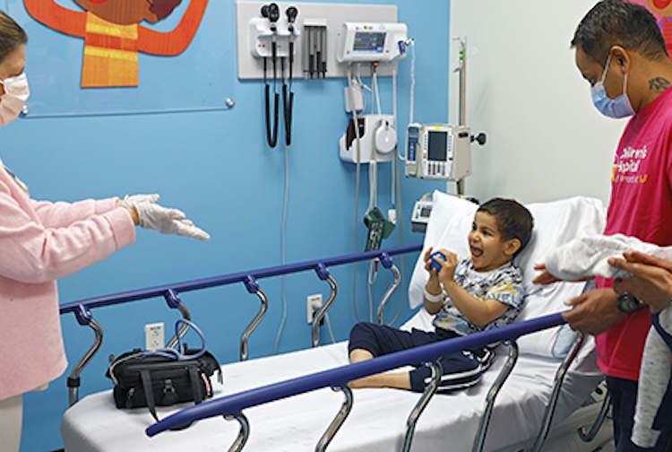 Nurses with patients and their parents in room.