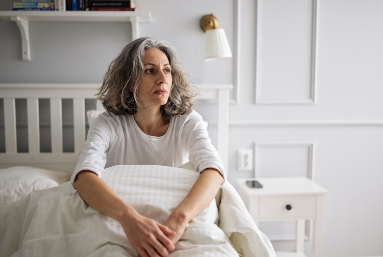 woman lying on bed, frustrated that she cannot sleep