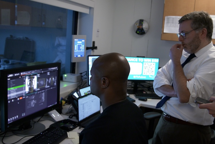 Members of Ross Southers' care team gather in a room to look at images from his MRI during the focused ultrasound procedure.