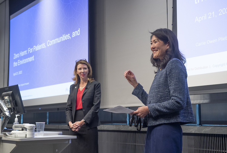 A close up photo of women in suits speaking for a presentation.