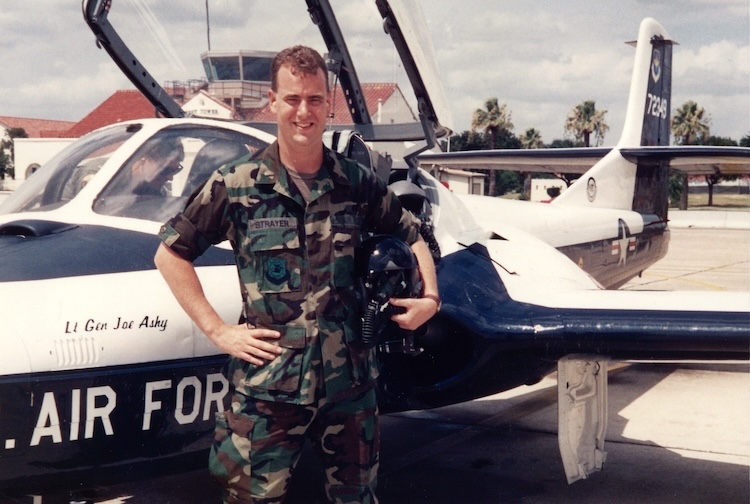 Man in standing next to air force airplane