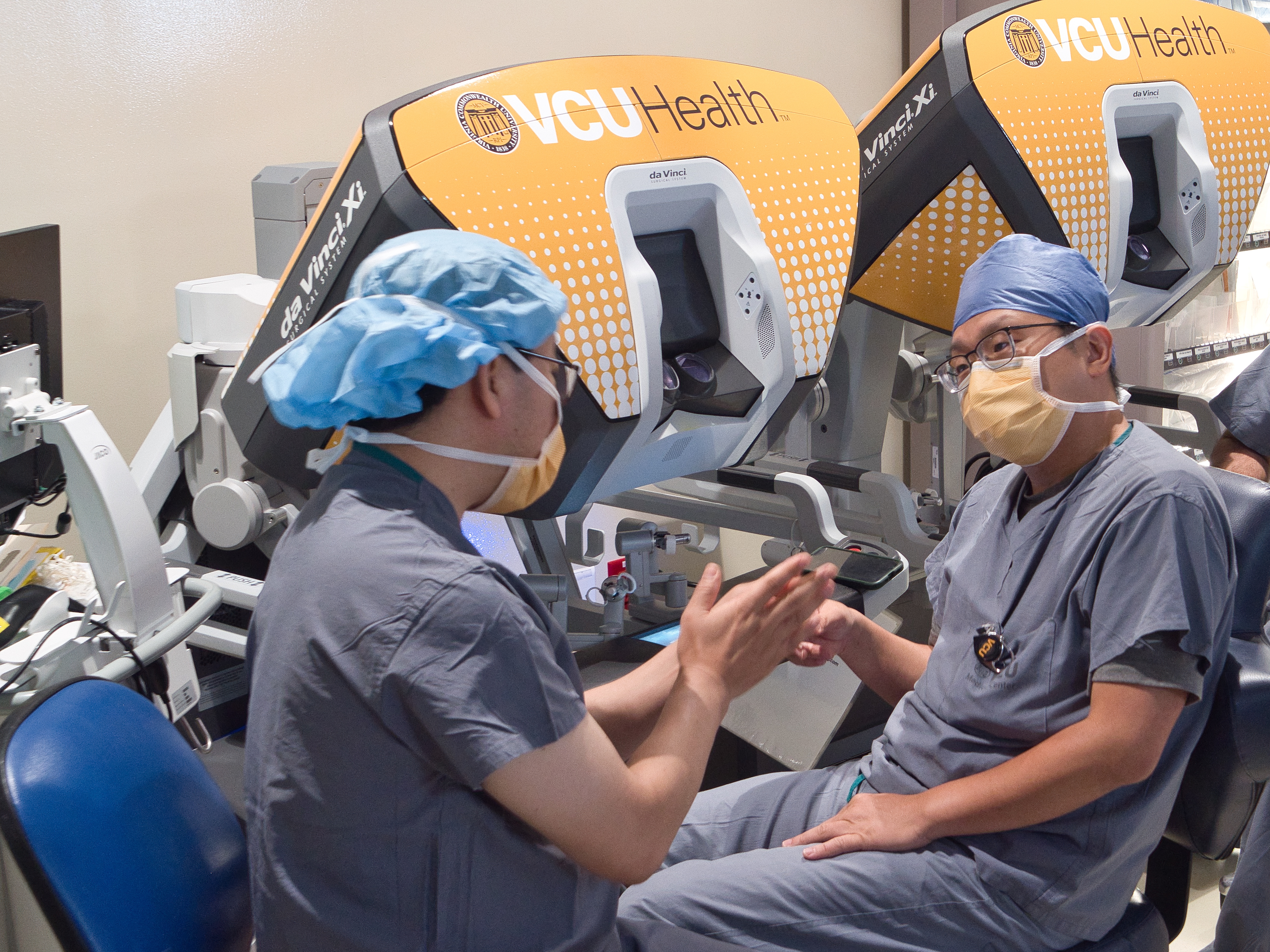 Two male doctors in blue scrubs talking.