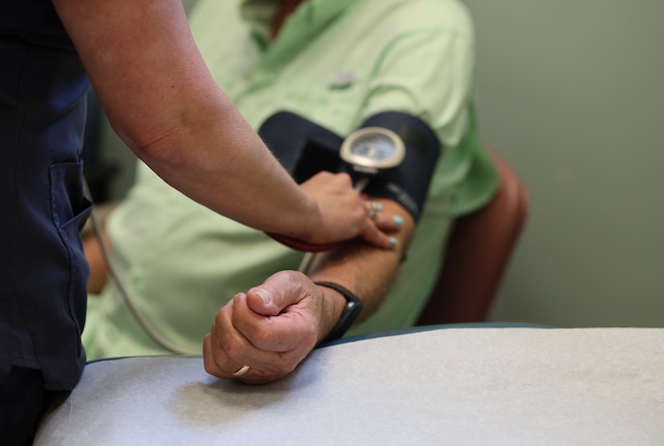 Cancer patient gets his blood pressure read by a nurse.
