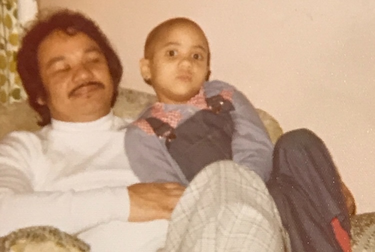 Father holding daughter while sitting in a chair 