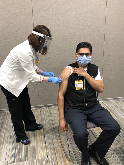 Stacy Davis vaccinates Saini Bikram, MD, the Hospitalist Director at VCU Health CMH.