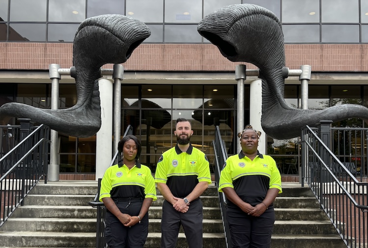 Three security officers in bright yellow jackets