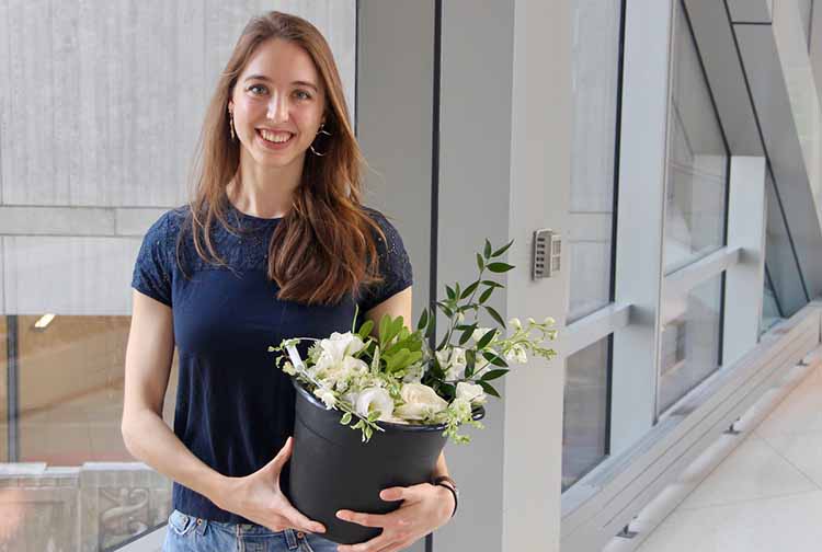 Eleanor Love holding flowers in hospital hallway
