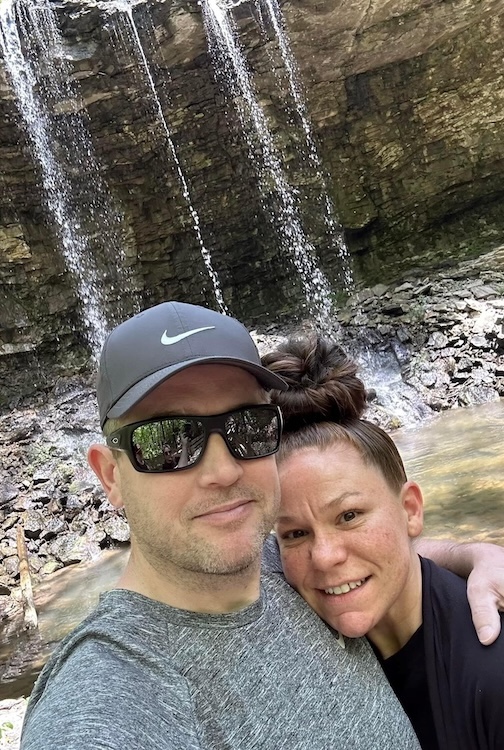 Man and woman with a waterfall behind them.