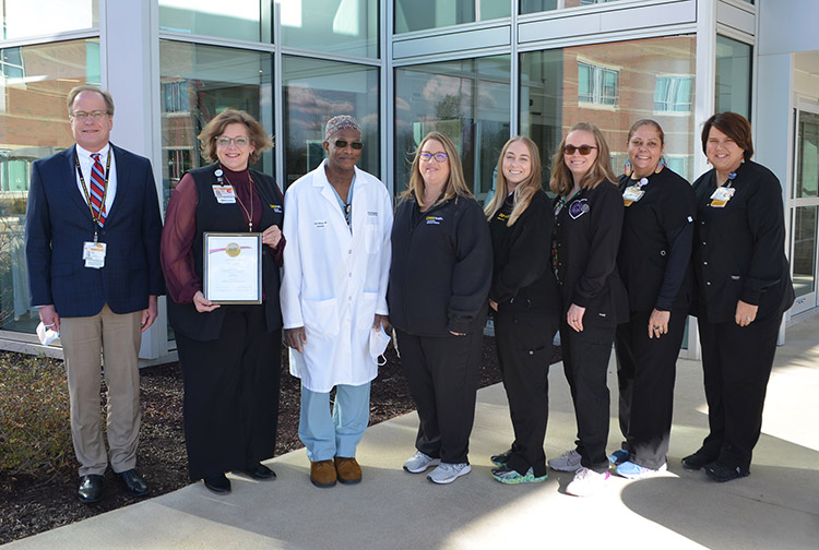 A group of health care workers stand outside a hospital