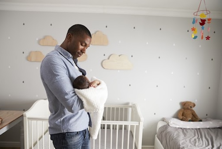 Father holding baby in nursery