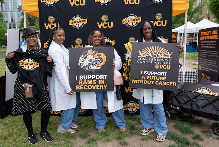People in white doctors coats in front of a sign
