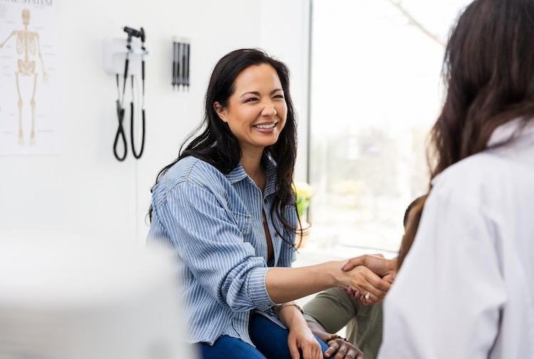 female patient smiles and shakes hands with the doctor