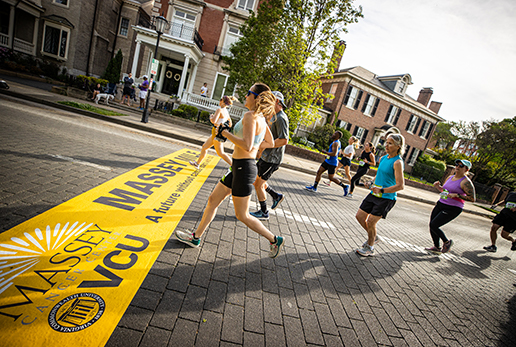 People running and crossing the finish line for Massey Comprehensive Cancer Center Challenge