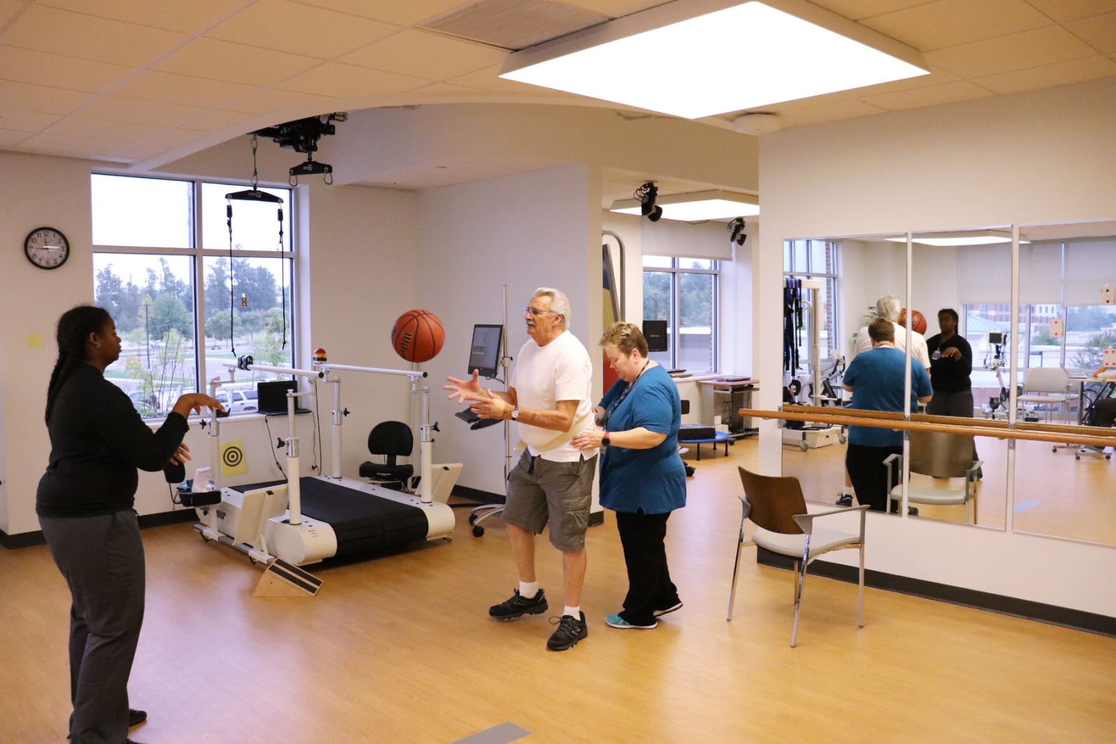 With the help of physical therapist Mary Beth O'Reilly, Corbin Cash plays catch with a physical therapy assistant while walking side-to-side.