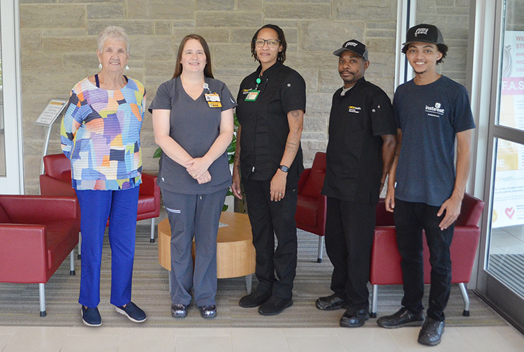A group of health care workers in front of a sitting area.