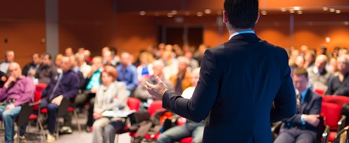Man speaking to a group of people in a conference room