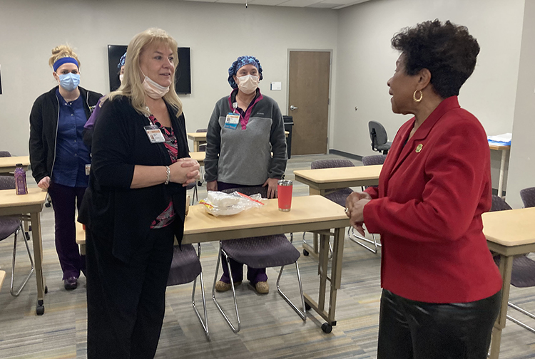a group of health care workers speak in a classroom