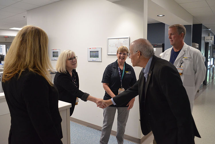 A group of people shake hands in an emergency room.