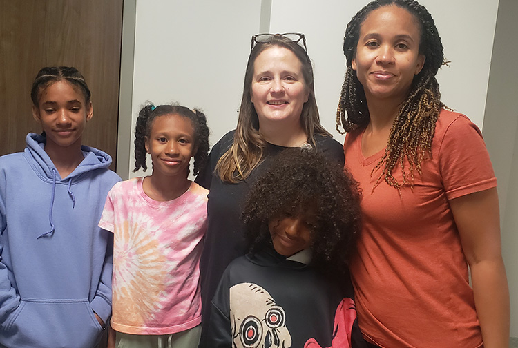 A nurse poses with a family.