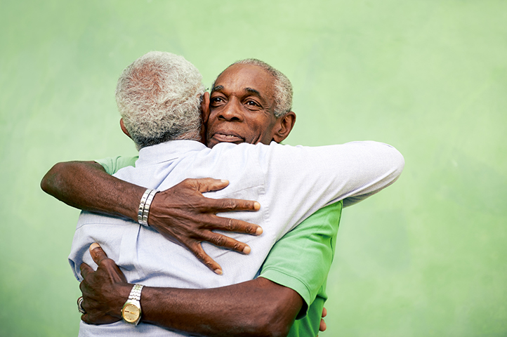 Two men hugging and smiling