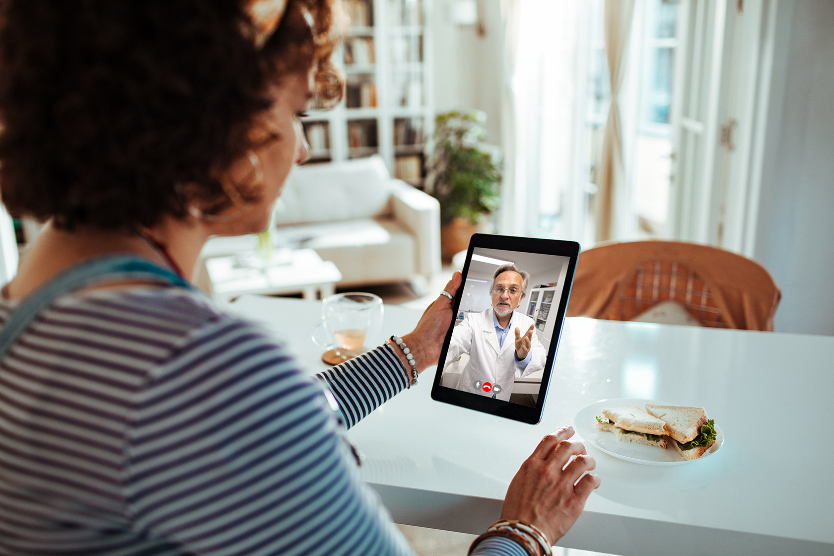 Woman at home having a telehealth appointment with healthcare provider