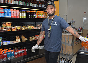 A man stocks the drink fridge in a hospital cafeteria.