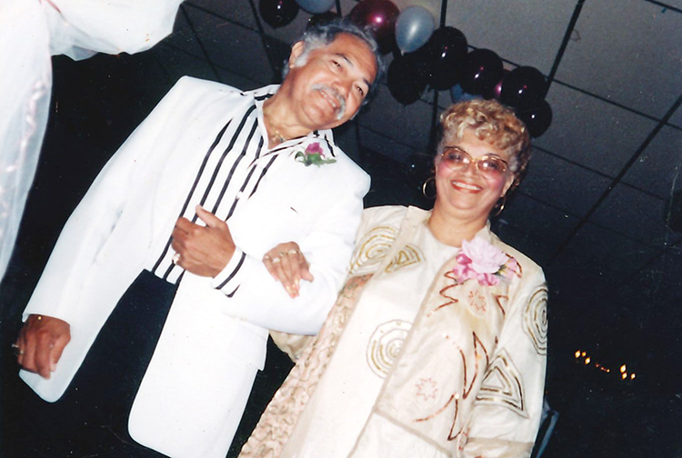 A well-dressed couple smiles for the camera.