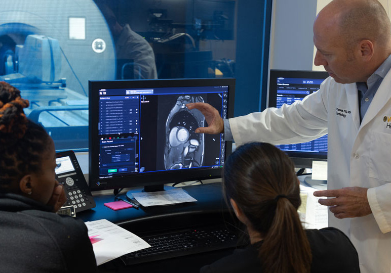 Medical professionals look at MRI scans on a computer screen in a hospital.