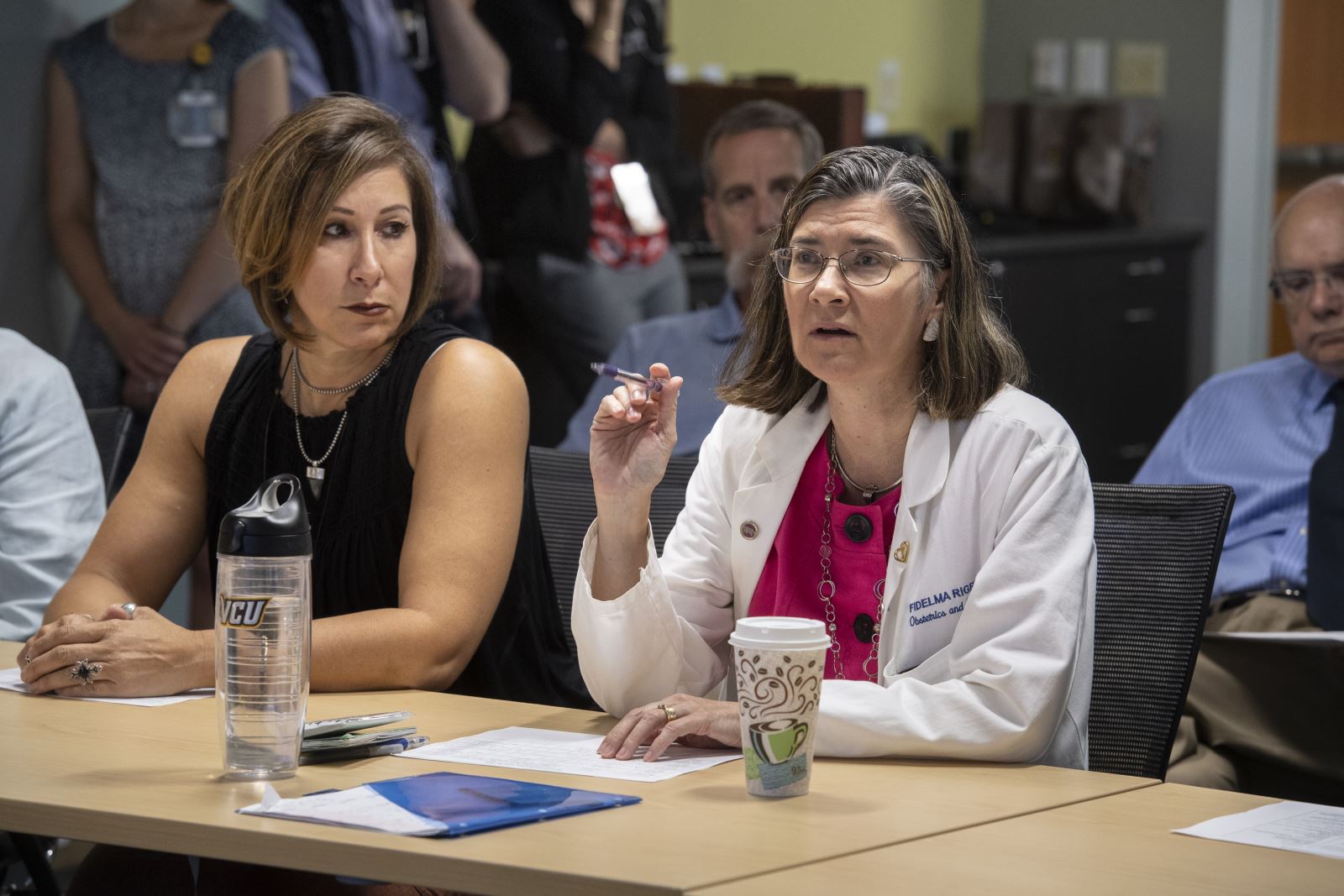Health providers sit at a table to discuss complex pre-natal care.