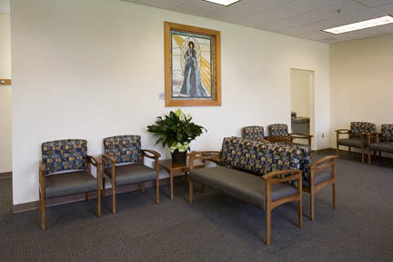 A waiting area with a gray floor and gray chairs.