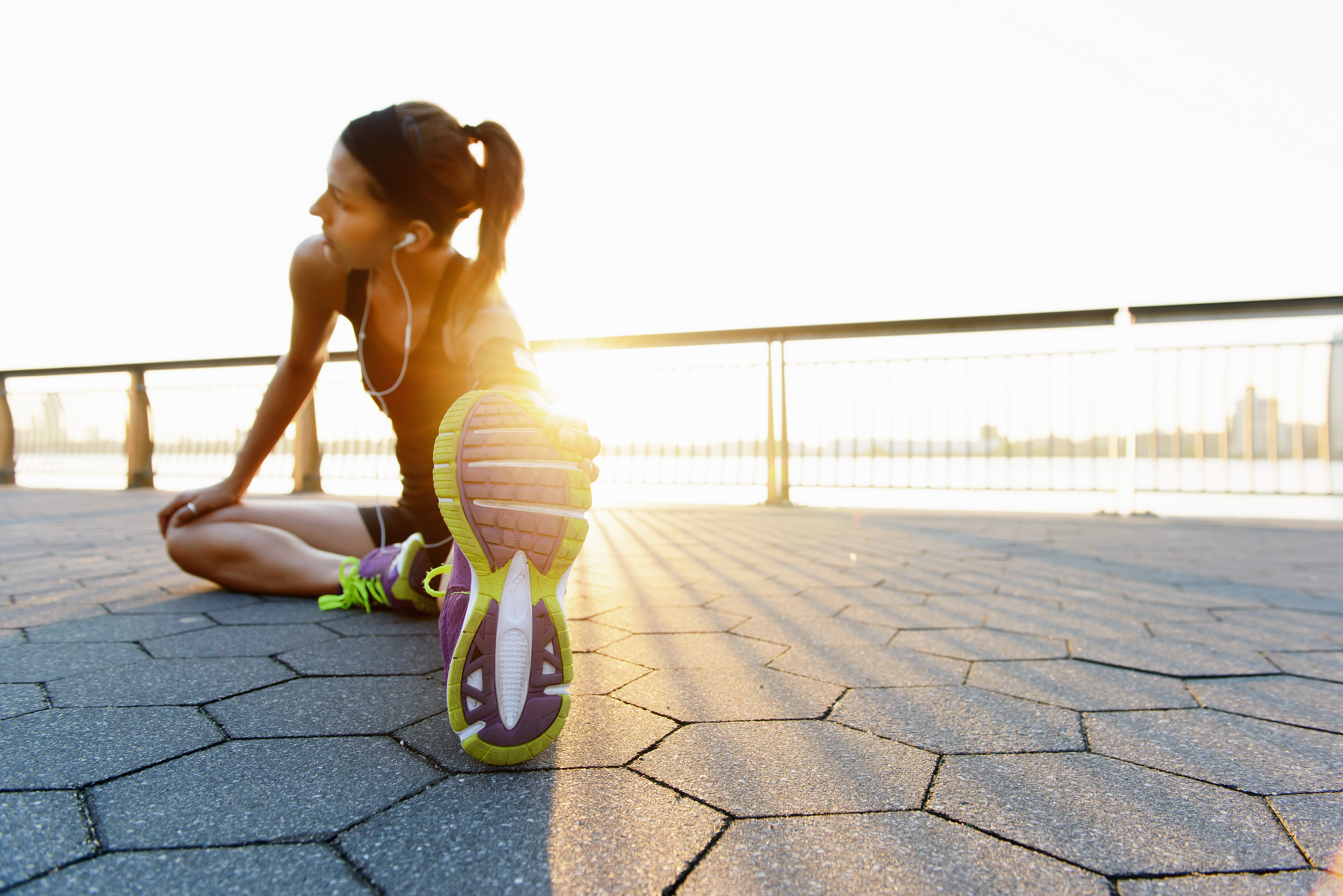 Female runner sitting on the ground and stretching