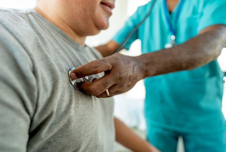 A provider listens to a patient's heart with a stethoscope.
